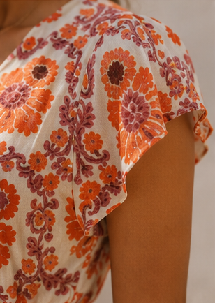 Detalhe da manga curta e fluida do vestido floral off-white