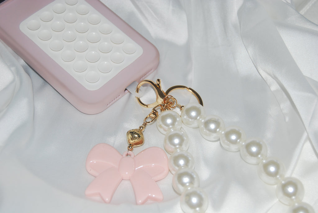 Chaveiro Rosé Pearl Bow — chaveiro com pérolas e laço rosa.