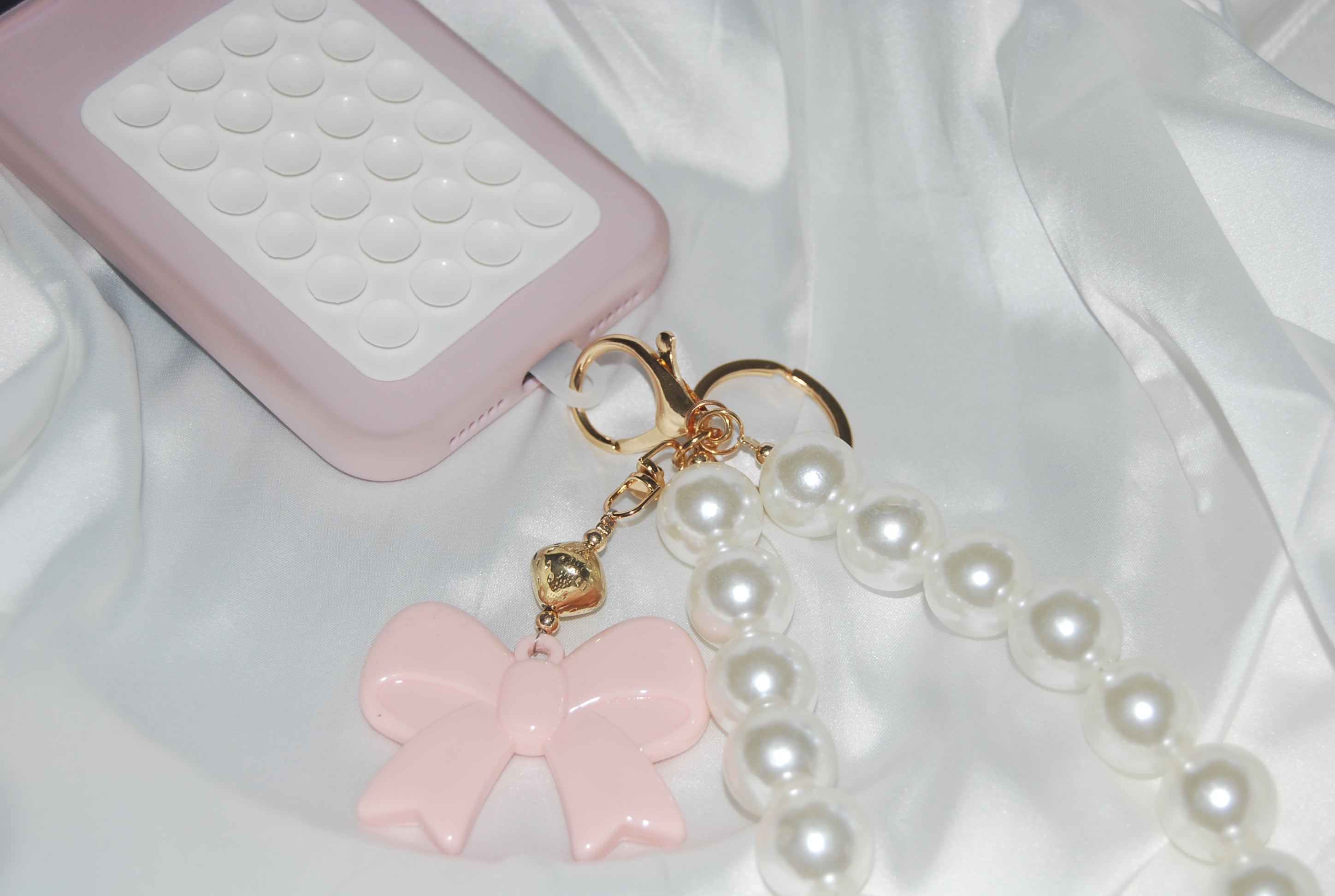 Chaveiro Rosé Pearl Bow — chaveiro com pérolas e laço rosa.