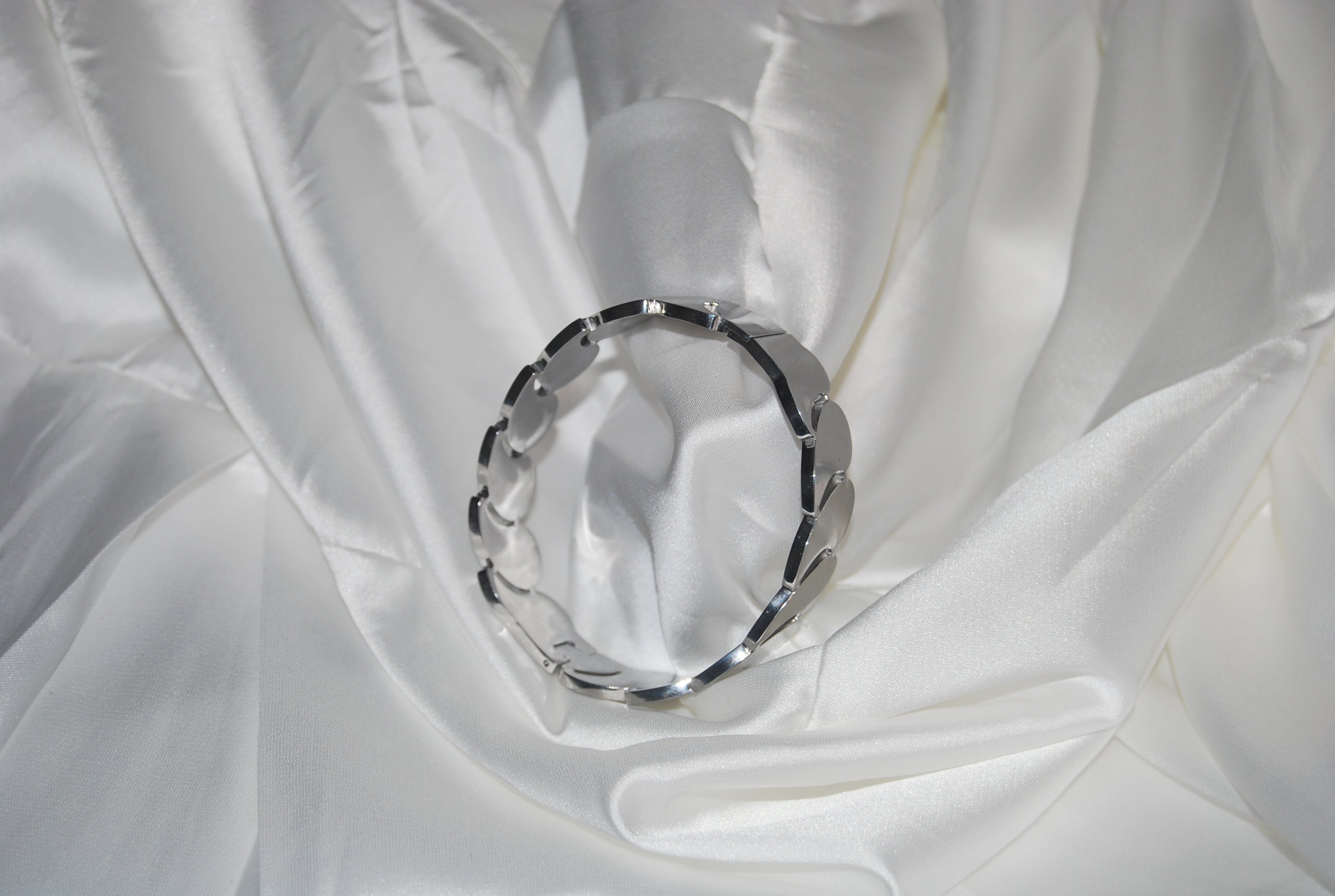 Pulseira prateada com elos em forma de folha/escama