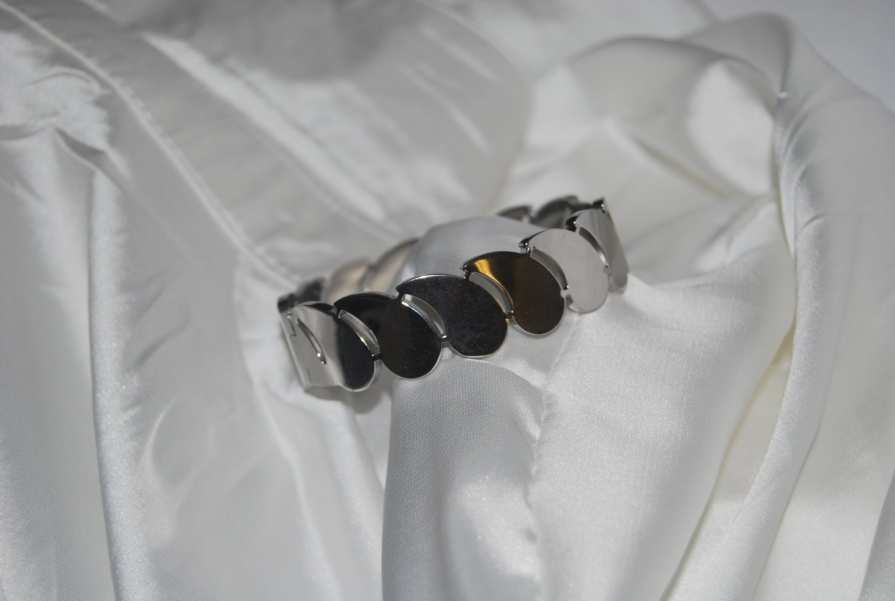 Pulseira prateada com elos em forma de folha/escama