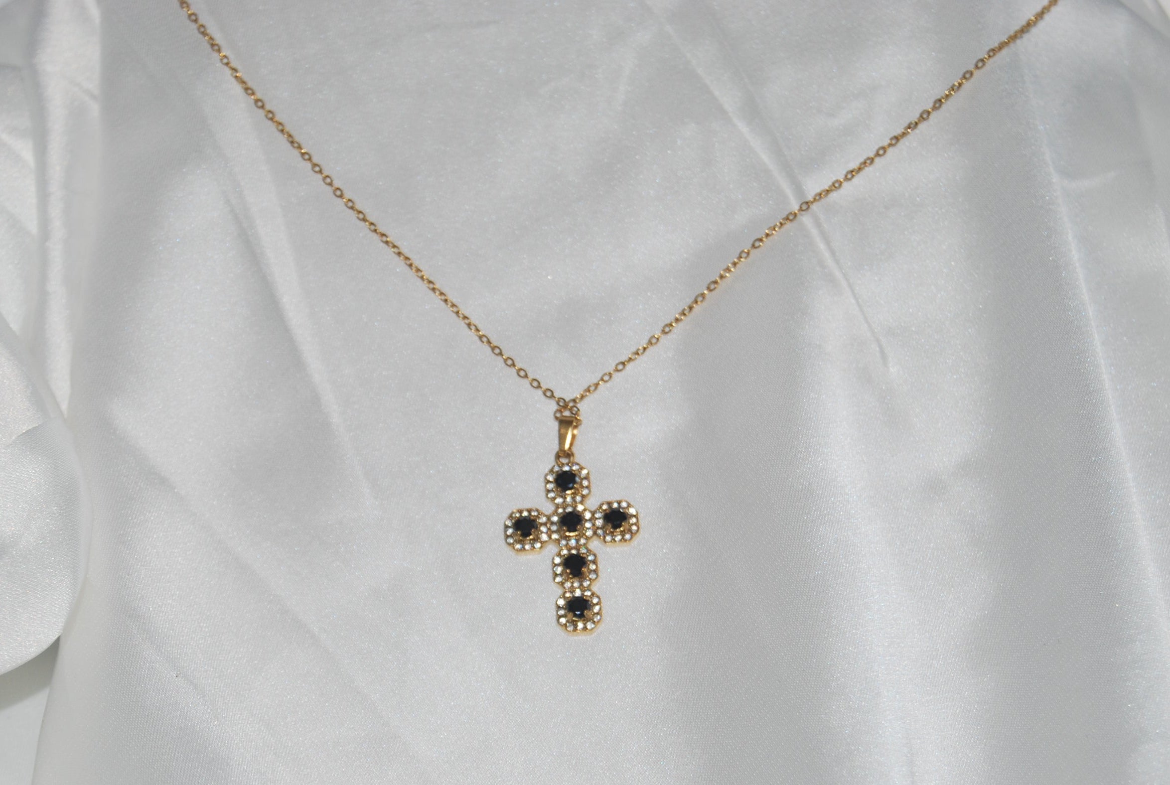 Colar dourado com cruz cravejada de zircónias escuras
