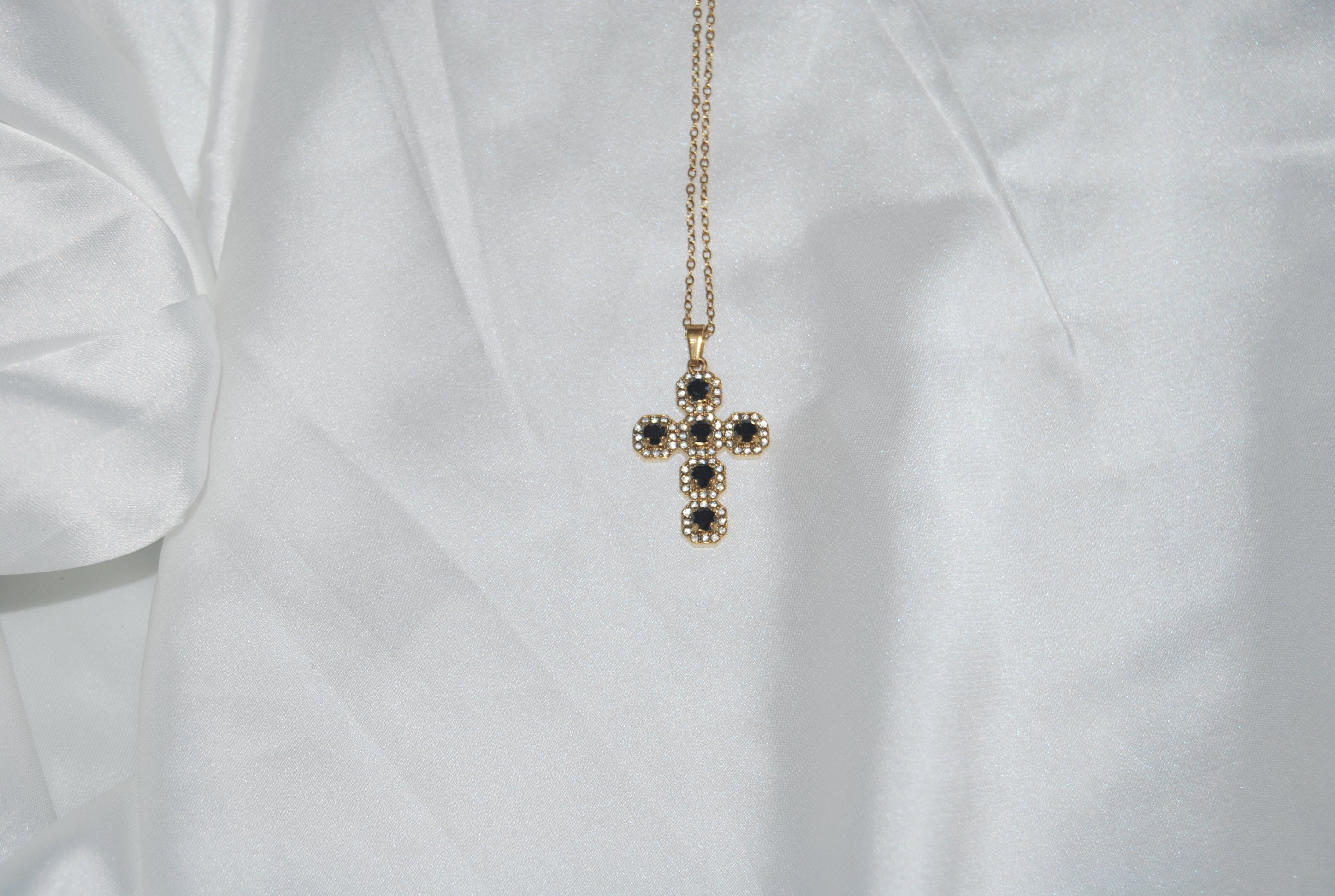 Colar dourado com cruz cravejada de zircónias escuras