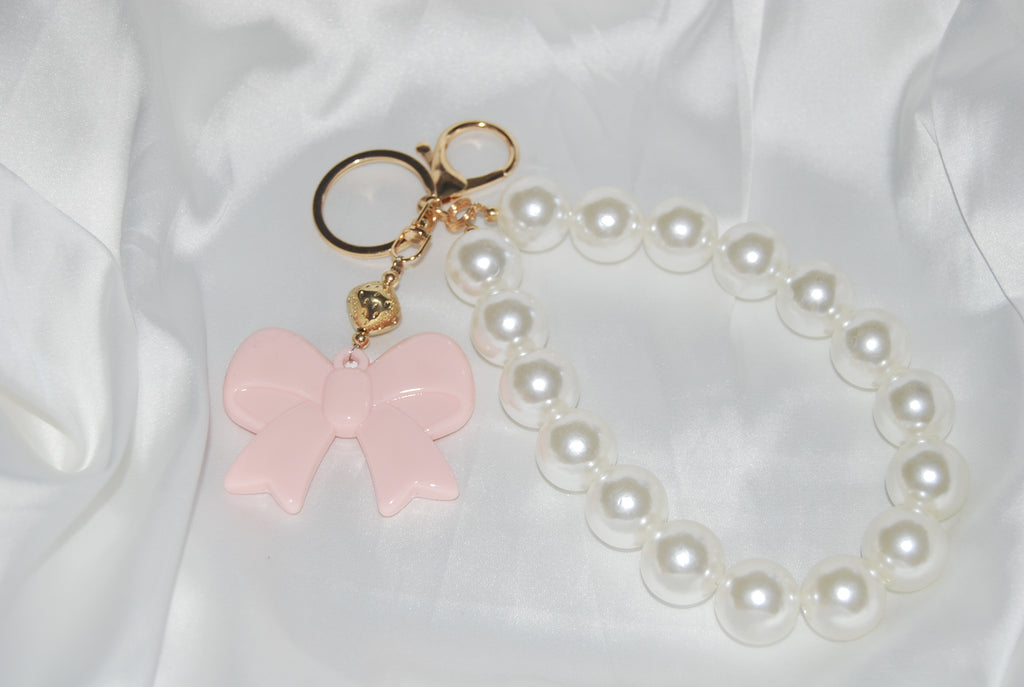 Chaveiro Rosé Pearl Bow — chaveiro com pérolas e laço rosa.