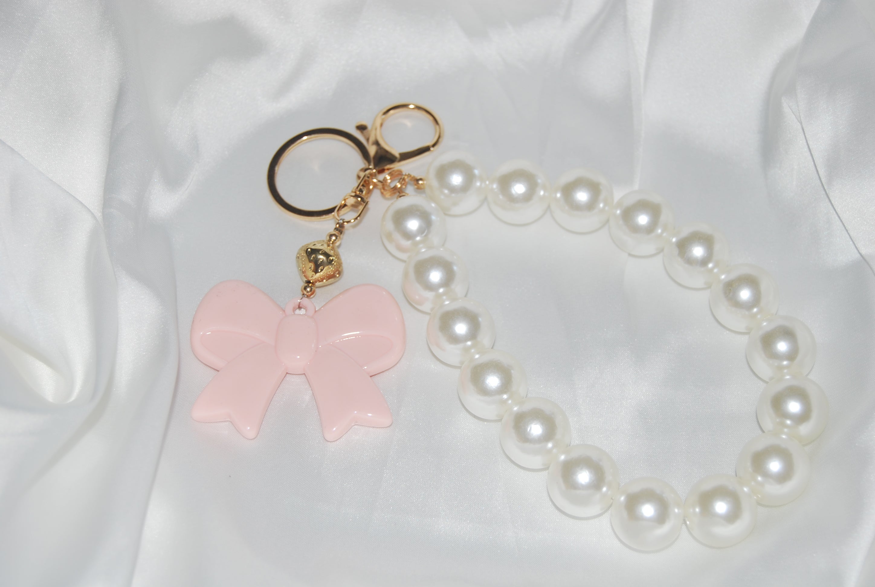Chaveiro Rosé Pearl Bow — chaveiro com pérolas e laço rosa.