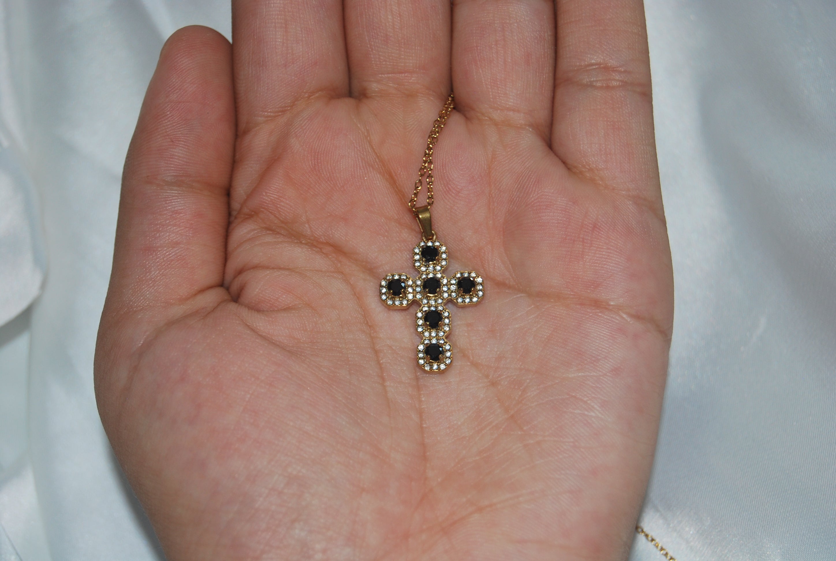 Colar dourado com cruz cravejada de zircónias escuras