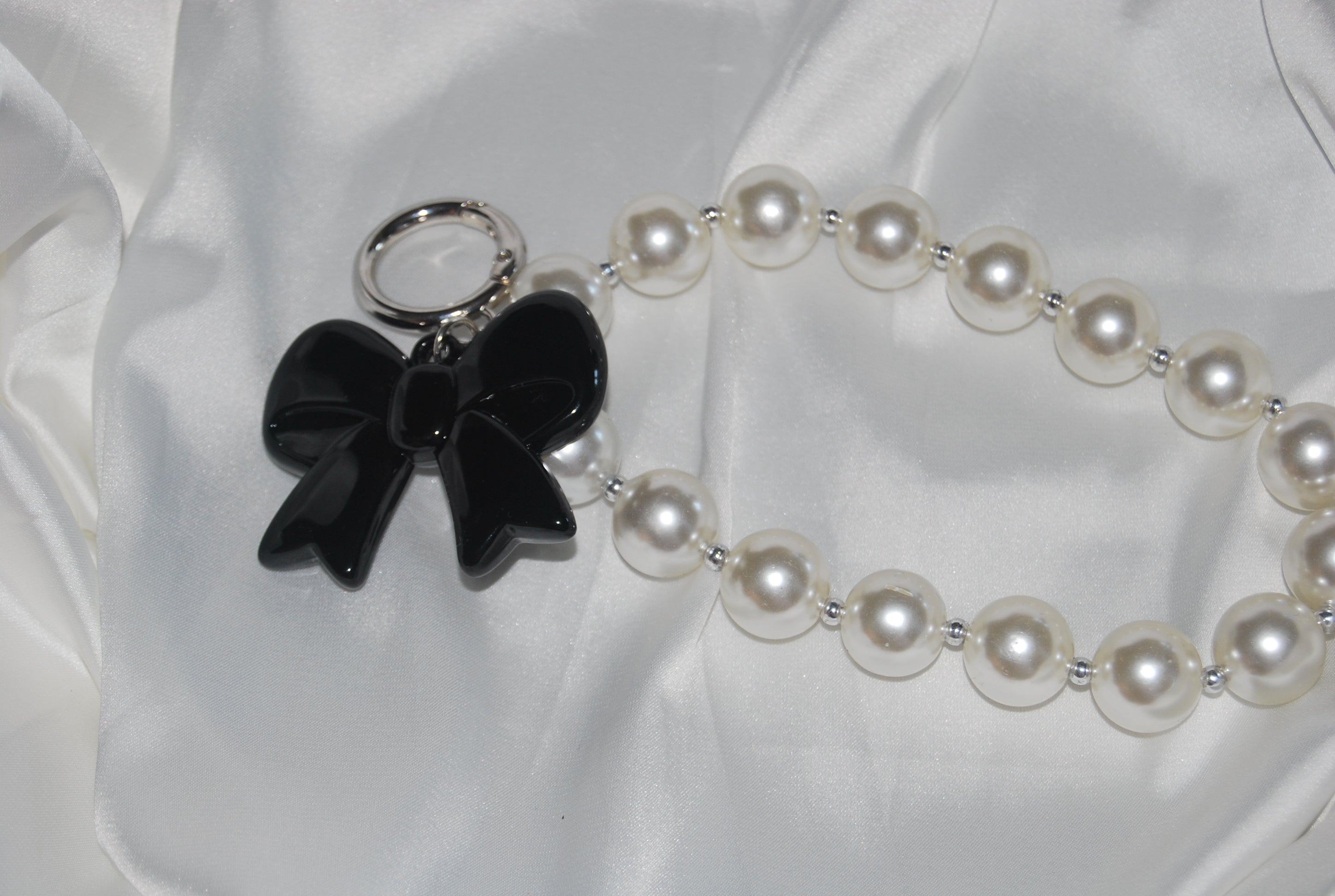 Chaveiro Rosé Pearl Bow — chaveiro com pérolas e laço rosa.