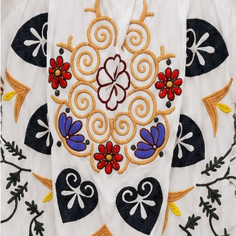 Vestido branco bordado floral, manga três quartos.