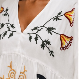 Vestido branco bordado floral, manga três quartos.