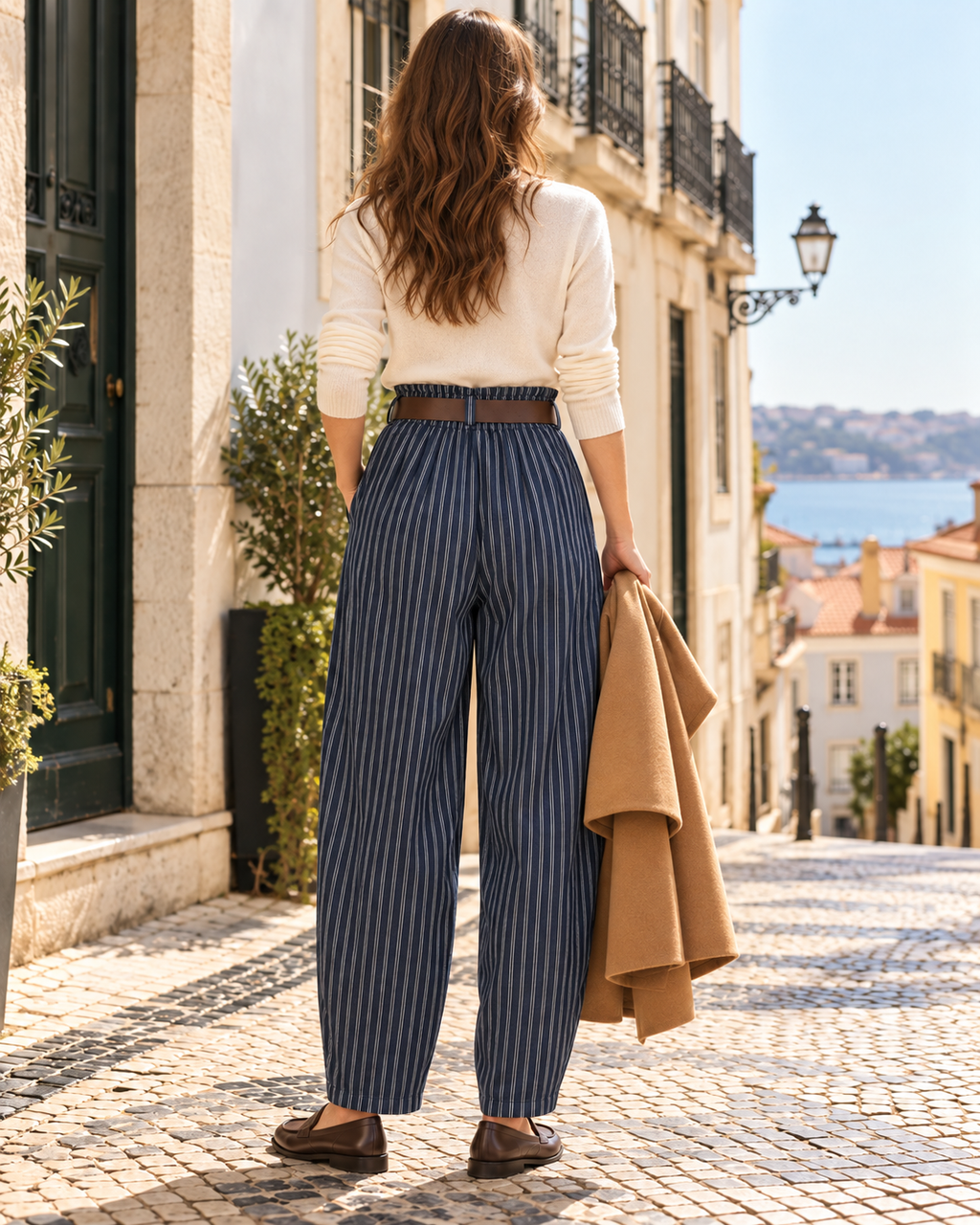 Calças azul-escuro às riscas brancas com elástico na cintura, vista de costas com modelo