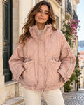 Casaco acolchoado rosa com gola alta e pesponto ondulado, vestido em modelo, vista de frente