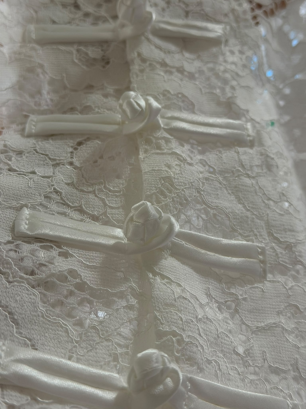 Detalhe dos fechos frontais em tecido do colete de renda H13329