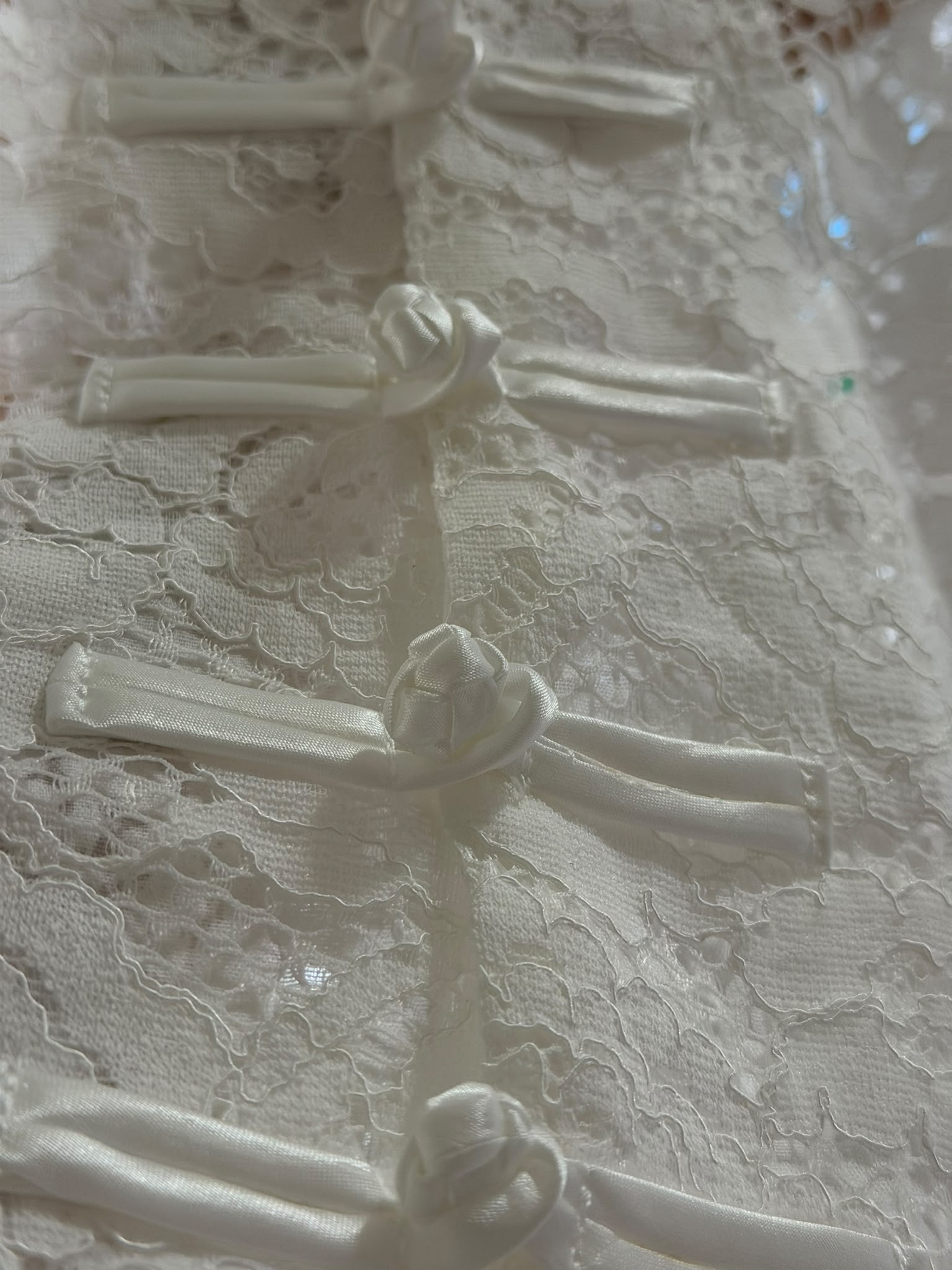 Detalhe dos fechos frontais em tecido do colete de renda H13329