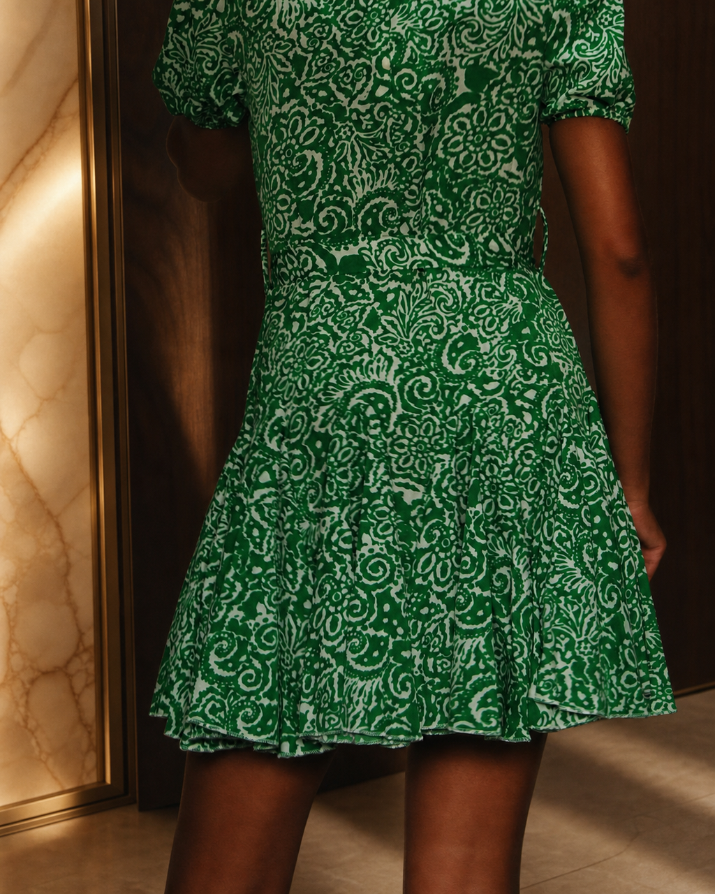 Detalhe do estampado branco e creme sobre fundo verde do vestido camiseiro