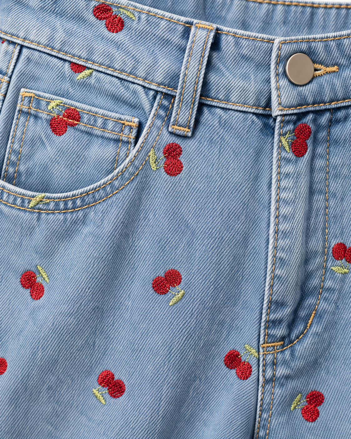 Detalhe do tecido denim e das cerejas vermelhas bordadas