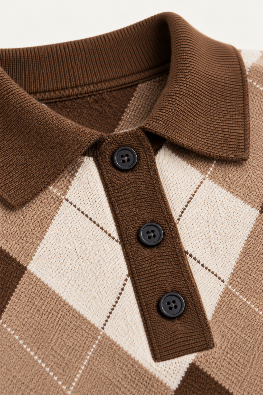Detalhe da gola polo, dos três botões e do padrão argyle da camisola chocolate