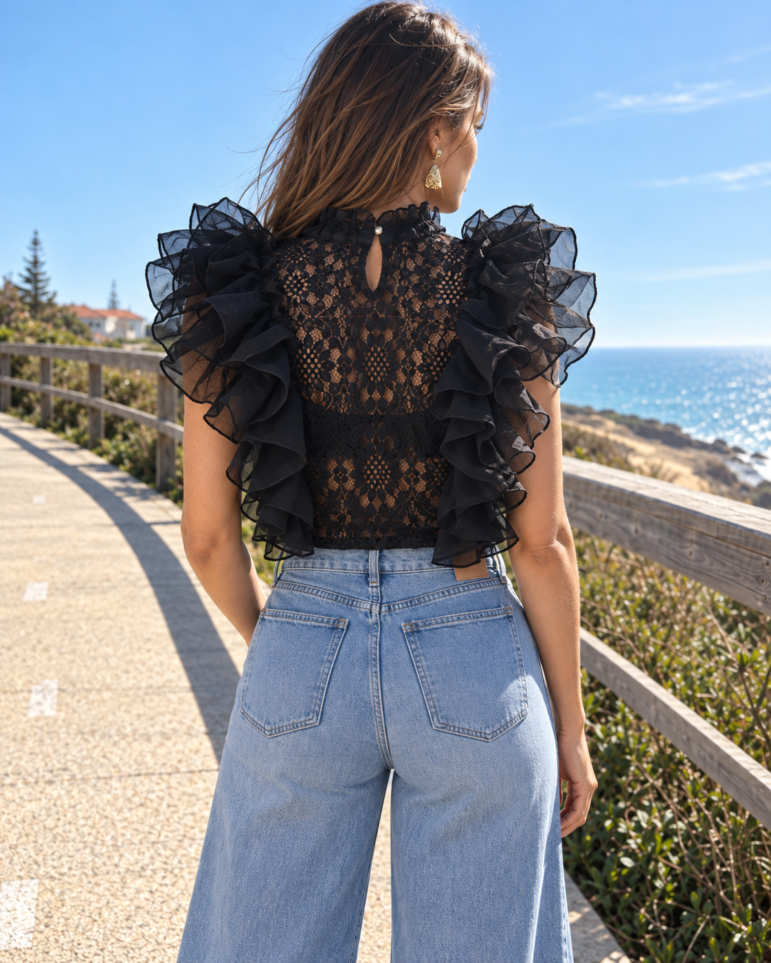 Modelo com top de renda preto Golden Days Paris, vista traseira com abertura em gota
